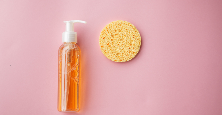 Bottle of facial cleansing oil beside a folded towel